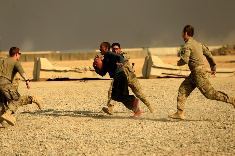 U.S. soldiers play football on Thanksgiving Day inside the army base in Qayyara, Iraq, November 2016.