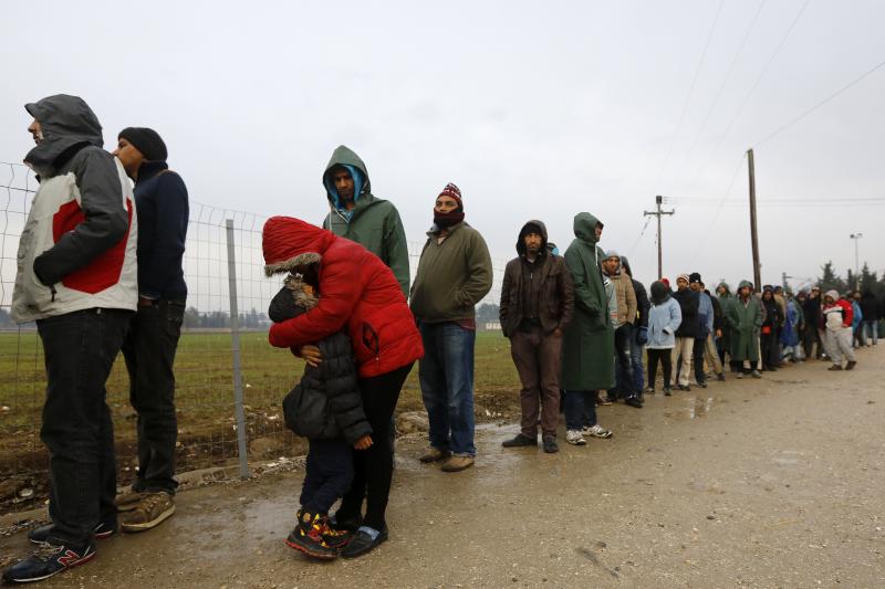 A stranded Iranian woman embraces her daughter as hundreds of migrants line up during food distribution at the Greek-Macedonian border, near the Greek village of Idomeni, November 2015.