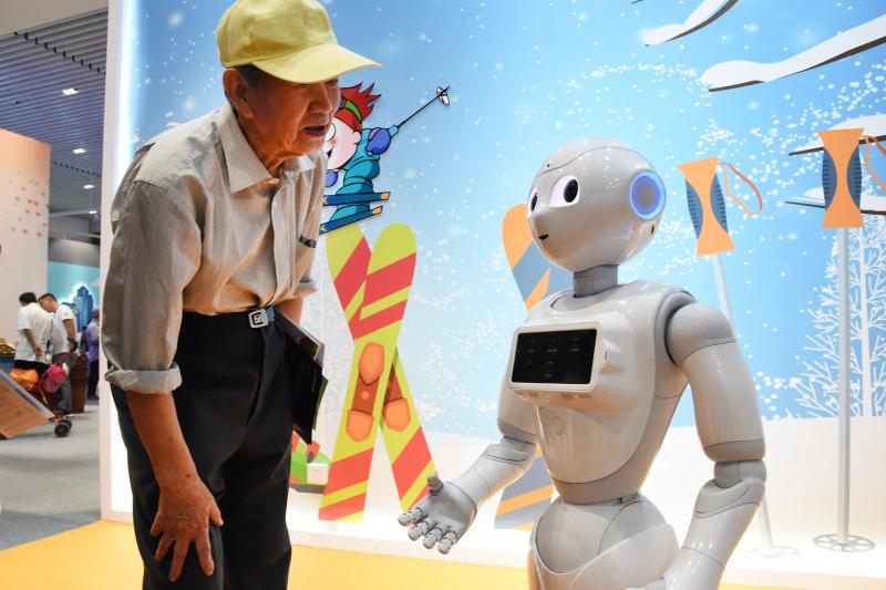 A man interacts with a cloud-based intelligent robot in Beijing, China, May 2019