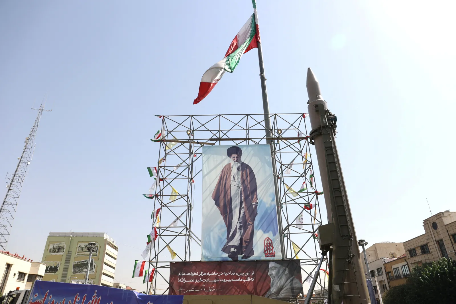 An Iranian missile next to a poster of Khamenei, Tehran, October 2024