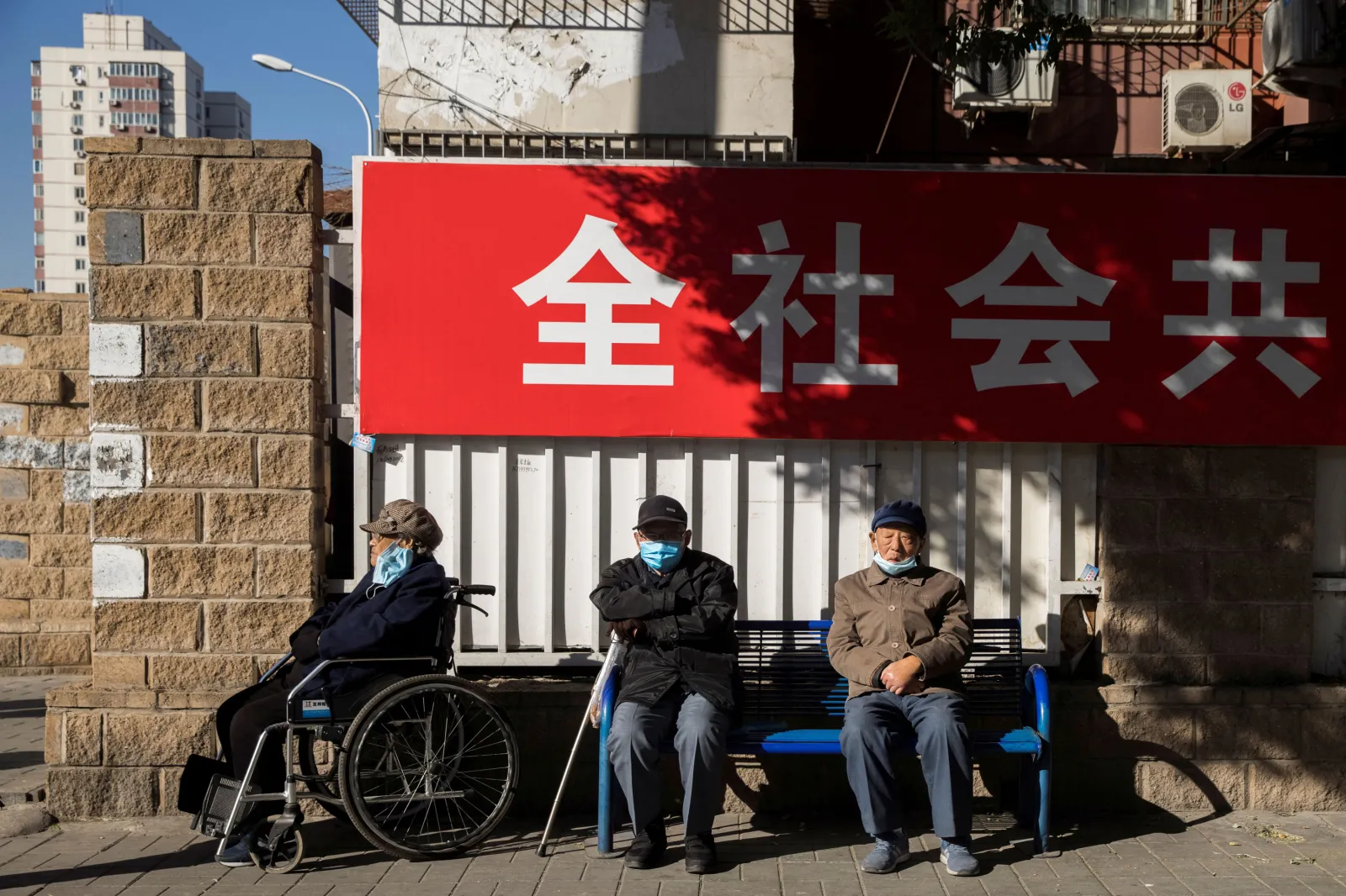 Sitting along the street during rush hour in Beijing, November 2020